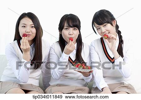 Stock Photo - students in uniform having strawberries. Fotosearch