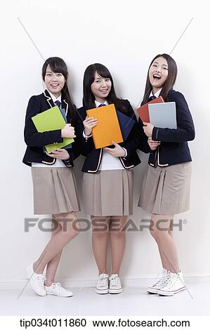 Stock Image - students in uniform holding books . Fotosearch