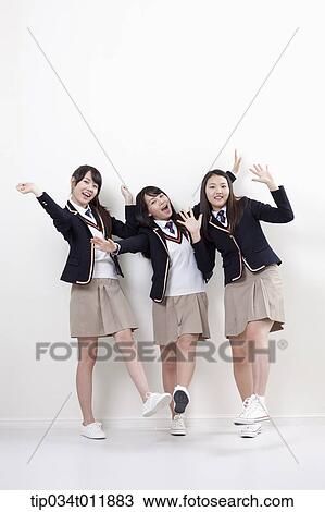 Stock Image - students in uniform posing happily. Fotosearch