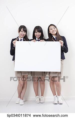 Picture - students in uniform posing with a white board. Fotosearch