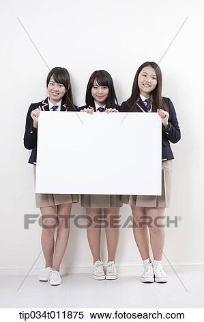 Stock Photography - students in uniform posing with a white board. Fotosearch