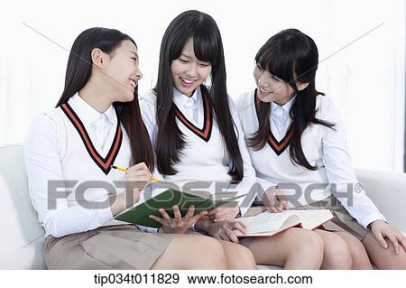Stock Photo - students in uniform sitting on a couch. Fotosearch