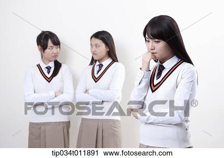 Stock Image - students in uniform staring at each other. Fotosearch