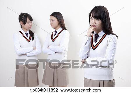 Stock Image - students in uniform staring at each other. Fotosearch