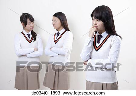 Stock Image - students in uniform staring at each other. Fotosearch