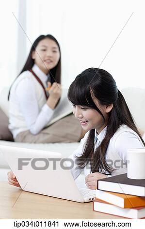 Stock Image - students in uniform studying together in a room. Fotosearch