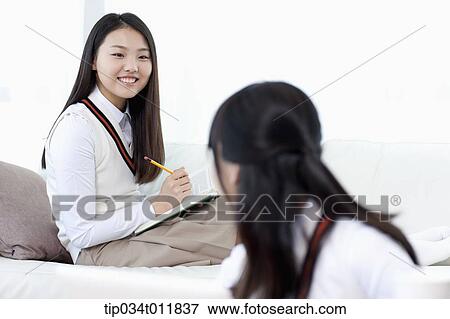 Stock Photo - students in uniform studying together in a room. Fotosearch