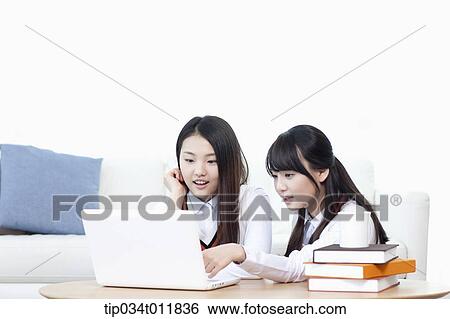 Stock Photograph - students in uniform using laptop together. Fotosearch