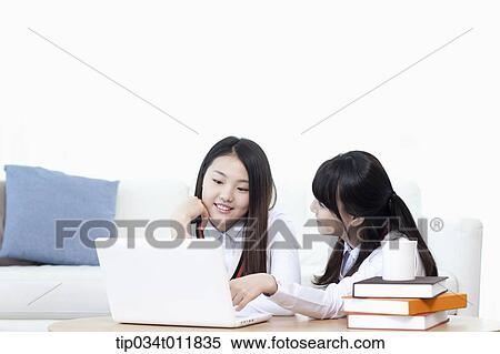 Stock Photography - students in uniform using laptop together. Fotosearch