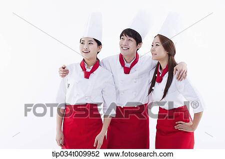 Stock Image - three cook with chef hats looking at same place. Fotosearch