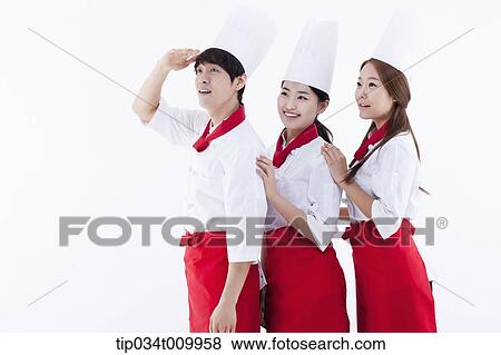 Stock Photo - three cook with chef hats looking at same place. Fotosearch