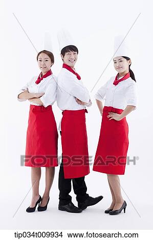Picture - three cook with chef hats posing together in white background. Fotosearch