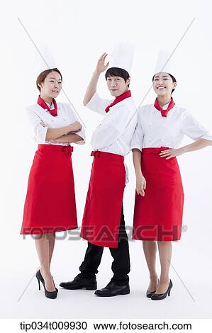 Stock Image - three cook with chef hats posing together in white background. Fotosearch