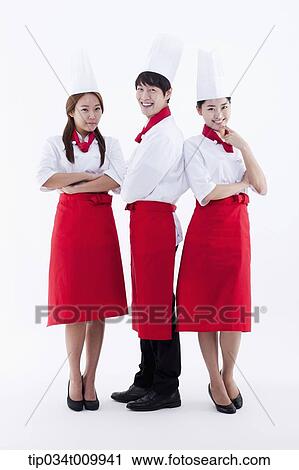 Stock Image - three cook with chef hats posing together in white background. Fotosearch
