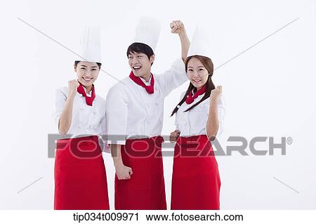Stock Image - three cook with chef hats posing cheerfully. Fotosearch
