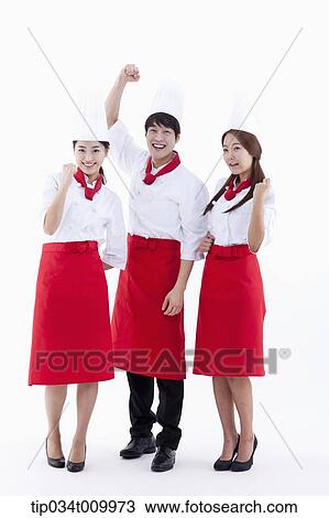 Stock Image - three cook with chef hats posing cheerfully. Fotosearch