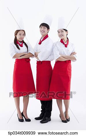 Stock Photo - three cook with chef hats posing together in white background. Fotosearch