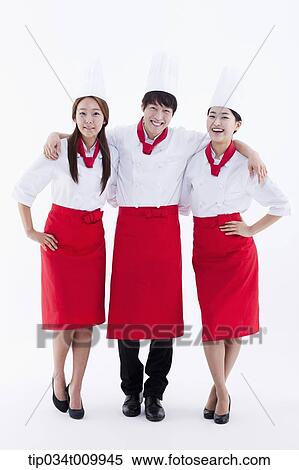 Stock Photography - three cook with chef hats posing together in white background. Fotosearch