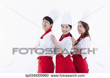 Stock Image - three cook with chef hats standing in a line . Fotosearch