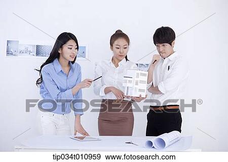three interior designers looking at a model house View Large Photo Image Stock Photo - three interior designers looking at a model house. Fotosearch