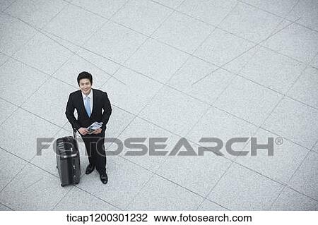 Stock Image - top down view of businessman with suitcase in the airport. Fotosearch