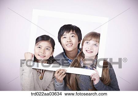 two girls and a boy holding blank board View Large Photo Image Picture - two girls and a boy holding blank board. Fotosearch