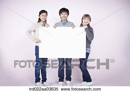 two girls and a boy holding blank board View Large Photo Image Stock Photography - two girls and a boy holding blank board. Fotosearch
