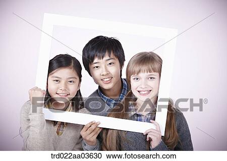 two girls and a boy with empty frame around themselves View Large Photo Image Stock Image - two girls and a boy with empty frame around themselves. Fotosearch