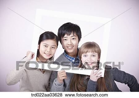 two girls and a boy with empty frame around themselves View Large Photo Image Stock Photo - two girls and a boy with empty frame around themselves. Fotosearch