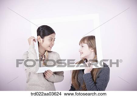 two girls with empty frame around themselves View Large Photo Image Picture - two girls with empty frame around themselves. Fotosearch