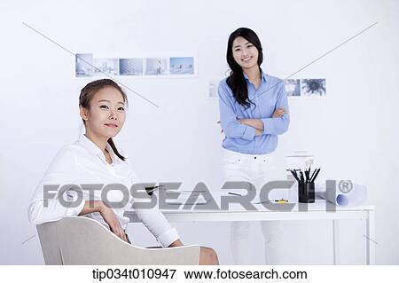 Stock Photo - two interior designers at a desk. Fotosearch