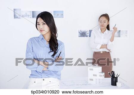 Stock Image - two interior designers with a model house. Fotosearch