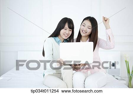 two ladies using laptop together View Large Photo Image Picture - two ladies using laptop together. Fotosearch