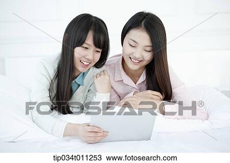 two ladies using tablet PC together View Large Photo Image Stock Image - two ladies using tablet PC together. Fotosearch