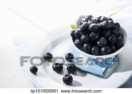 Stock Image - a bowl of blue berries on a plate. Fotosearch