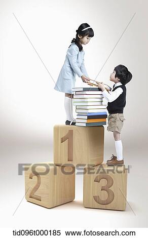 Stock Photography - a boy and a girl on number cubes with books . Fotosearch
