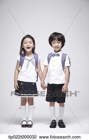 a boy and a girl wearing school bags holding hands View Large Photo Image Stock Image - a boy and a girl wearing school bags holding hands. Fotosearch