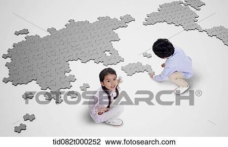 a boy and girl building map with puzzle pieces View Large Photo Image Stock Image - a boy and girl building map with puzzle pieces . Fotosearch