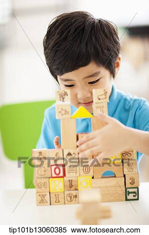 a boy building a castle with wood cubes View Large Photo Image Stock Photography - a boy building a castle with wood cubes. Fotosearch