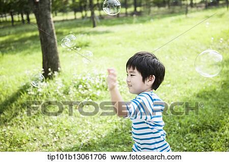 a boy chasing soap bubbles View Large Photo Image Stock Photograph - a boy chasing soap bubbles. Fotosearch