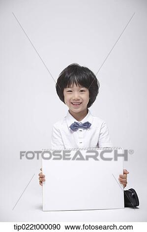 Stock Image - a boy holding a blank sketch book. Fotosearch