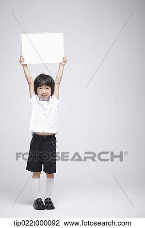 Stock Image - a boy holding a blank sketch book. Fotosearch