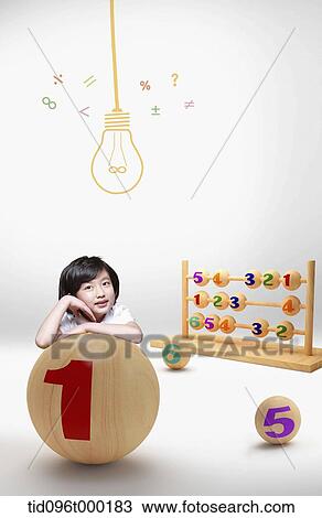Stock Image - a boy leaning on a ball with number one sign . Fotosearch