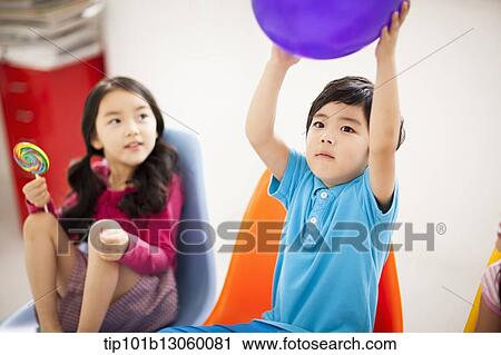 a boy playing with a balloon View Large Photo Image Stock Image - a boy playing with a balloon. Fotosearch