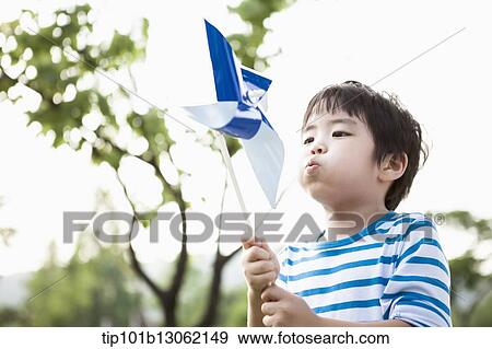 a boy playing with a toy wind mill View Large Photo Image Stock Photo - a boy playing with a toy wind mill. Fotosearch