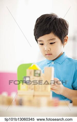 a boy playing with wood cubes with icons View Large Photo Image Stock Photography - a boy playing with wood cubes with icons. Fotosearch