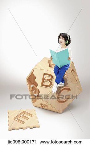 a boy reading a book with alphabet toy View Large Photo Image Stock Image - a boy reading a book with alphabet toy. Fotosearch