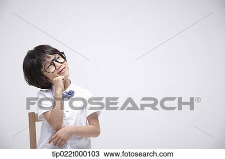 a boy sitting on a chair thinking View Large Photo Image Stock Image - a boy sitting on a chair thinking. Fotosearch
