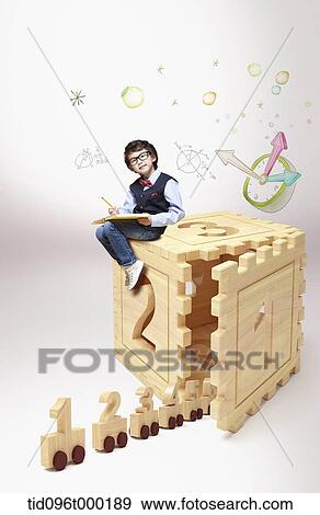 Stock Photo - a boy sitting on number cube . Fotosearch
