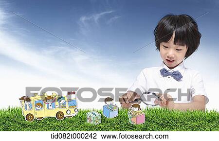 a boy using magnifying glass to look at cartoon toys View Large Photo Image Stock Image - a boy using magnifying glass to look at cartoon toys . Fotosearch
